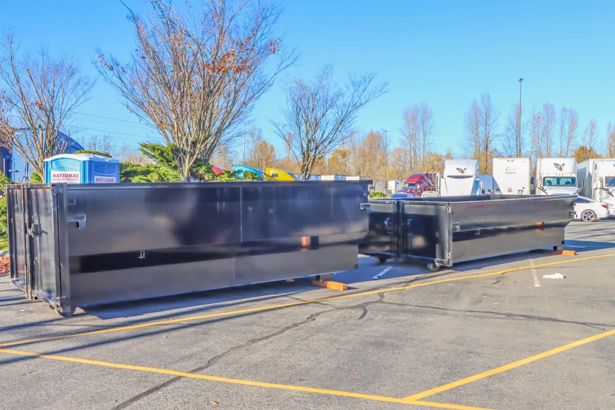 Professional dumpster rental service with roll-off container on residential driveway in Kill Devil Hills